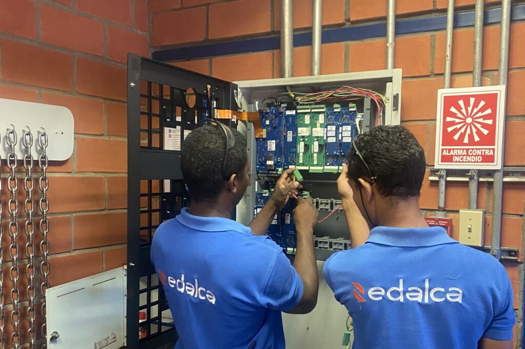 Técnicos de EDALCA realizando mantenimiento preventivo a un panel de incendio